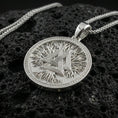 Load image into Gallery viewer, Polished silver valknut necklace on porous volcanic stone, geometric Norse knot medallion with detailed border frame
