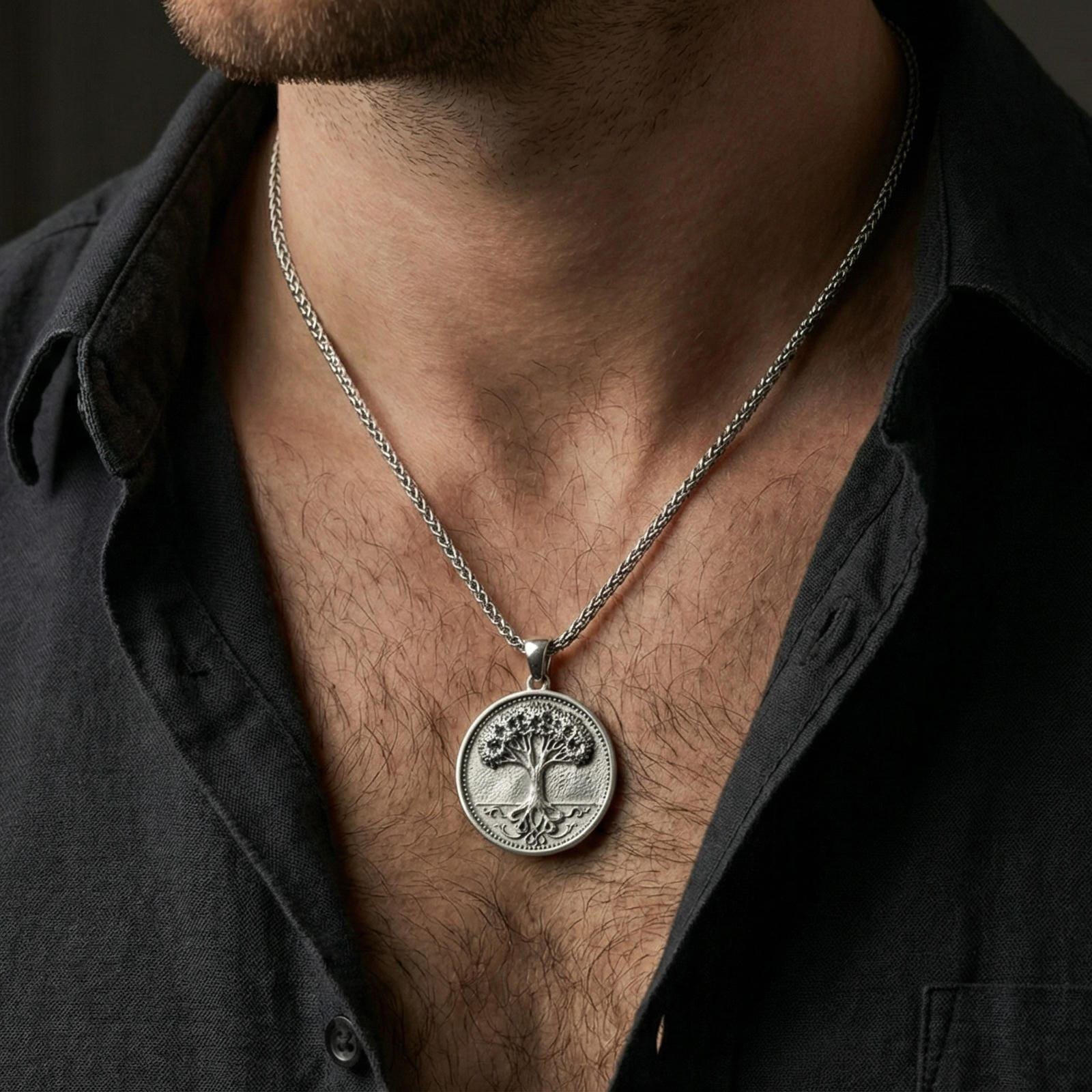 Polished silver Tree of Life medallion worn on neck, minimalist coin pendant with strong botanical symbolism