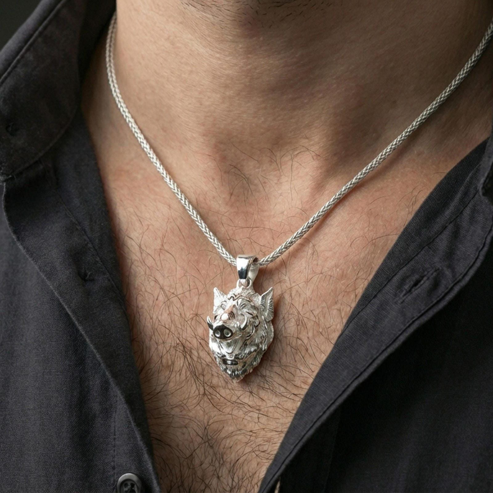Polished silver boar head pendant necklace on the neck, natural wear shot highlighting the detailed fur texture and strong sculpted profile
