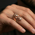 Load image into Gallery viewer, Rose gold plated bearded skull ring on a finger, close-up lifestyle image showcasing warm finish, ribbed beret texture and detailed skull expression
