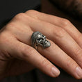 Load image into Gallery viewer, Oxidized beret skull ring worn on a finger, lifestyle close-up showing bold biker skull face, heavy beard texture and darkened recessed contrasts

