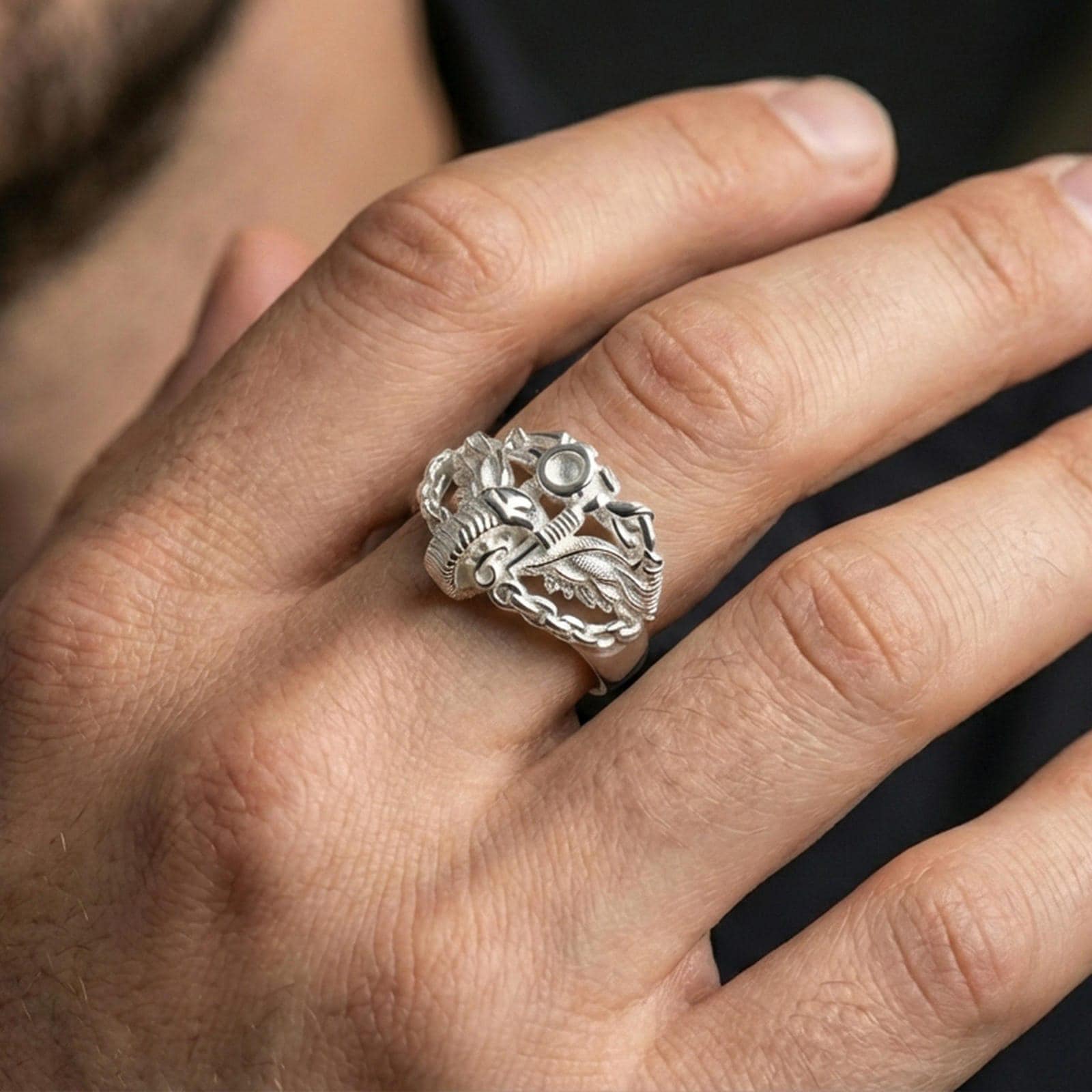 Polished silver motorcycle wing ring worn on the finger, wearable photo highlighting crisp chain links, reflective finish and mechanical detailing
