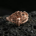 Load image into Gallery viewer, Rose gold plated motorcycle wing ring with chain band on textured volcanic rock, luxury close-up capturing warm plating glow and high-relief mechanical detailing
