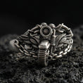 Load image into Gallery viewer, Oxidized sterling silver motorcycle ring with winged chain design on black volcanic rock, macro close-up highlighting darkened grooves and industrial biker detail
