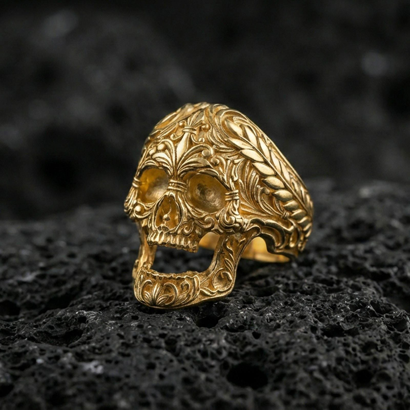 Gold plated baroque skull ring with intricate filigree patterns on volcanic rock, premium macro photo emphasizing warm tone, high-relief carving and gothic luxury style