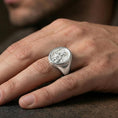 Load image into Gallery viewer, Polished silver Greek soldier signet ring worn on the finger, wearable photo highlighting reflective metal and engraved warrior scene
