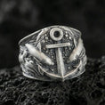 Load image into Gallery viewer, Oxidized sterling silver anchor ring with surrounding shark motifs and ocean-texture details, macro product photo on black volcanic rock
