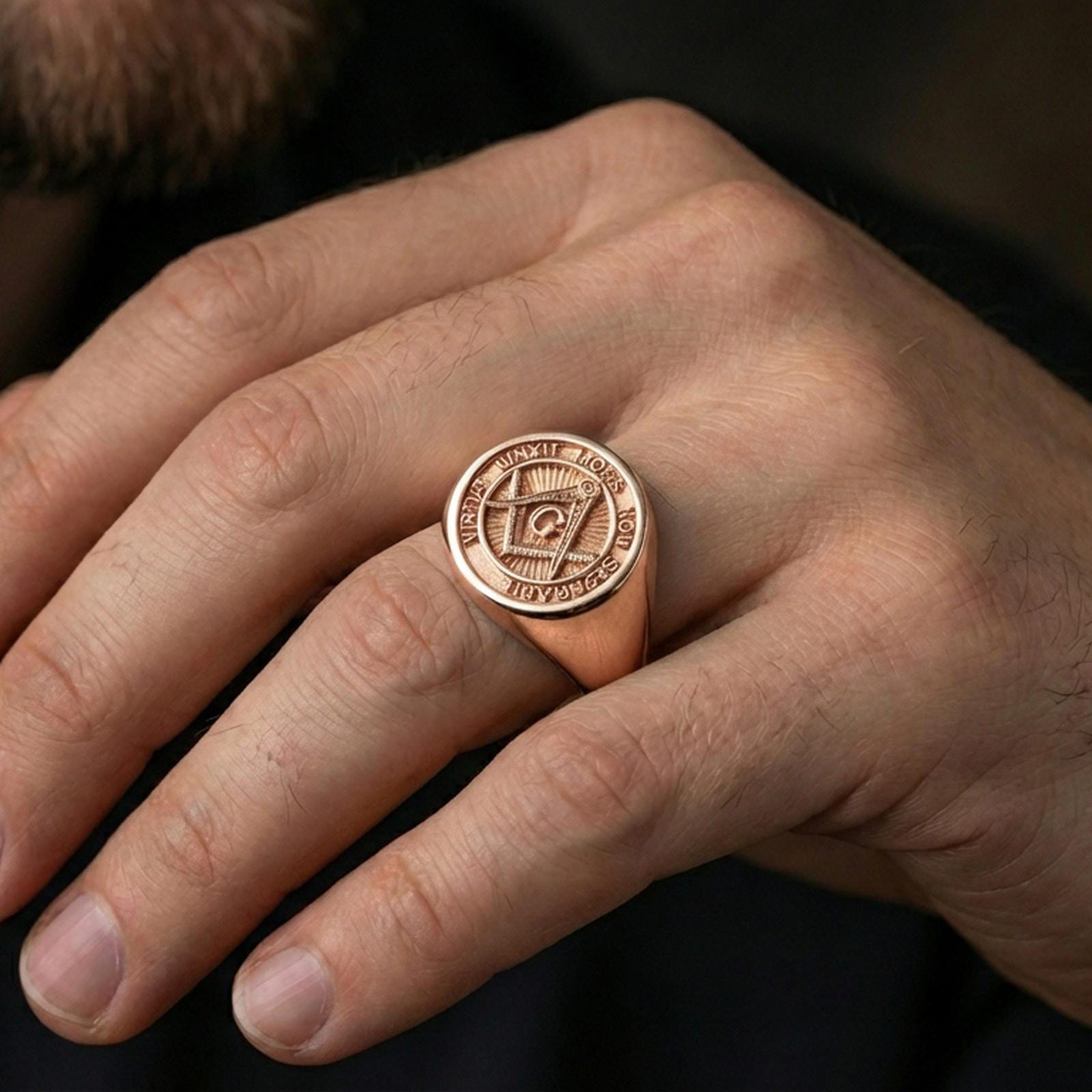 Rose gold plated Masonic signet ring on the finger, close-up lifestyle photo showing detailed motto border and bold signet profile