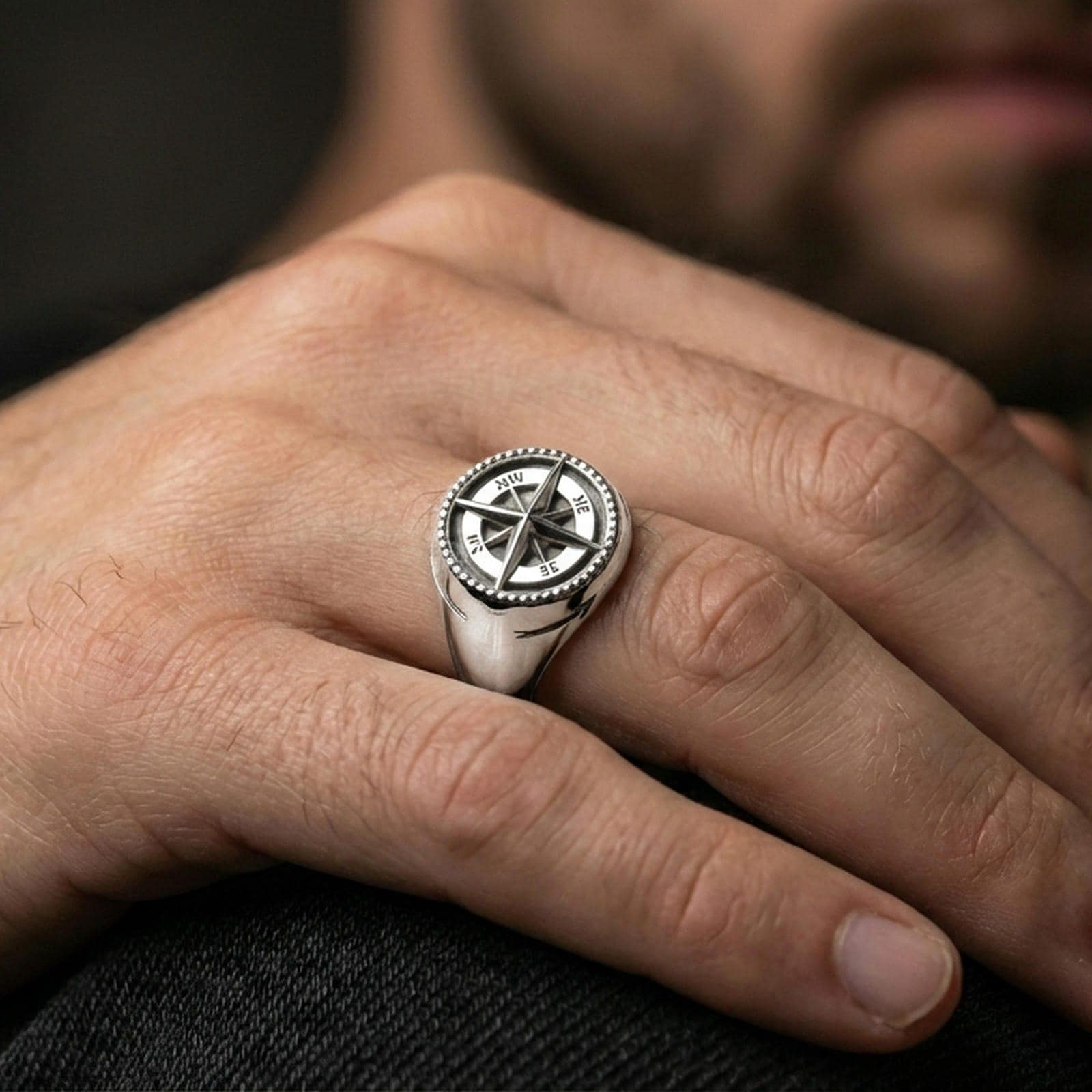 Polished silver compass ring on the finger, wearable shot focusing on the 3D wind rose face and clean tapered band