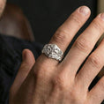 Load image into Gallery viewer, Polished silver fleur-de-lis ring on the finger, wearable shot focusing on the vine scrollwork and raised emblem
