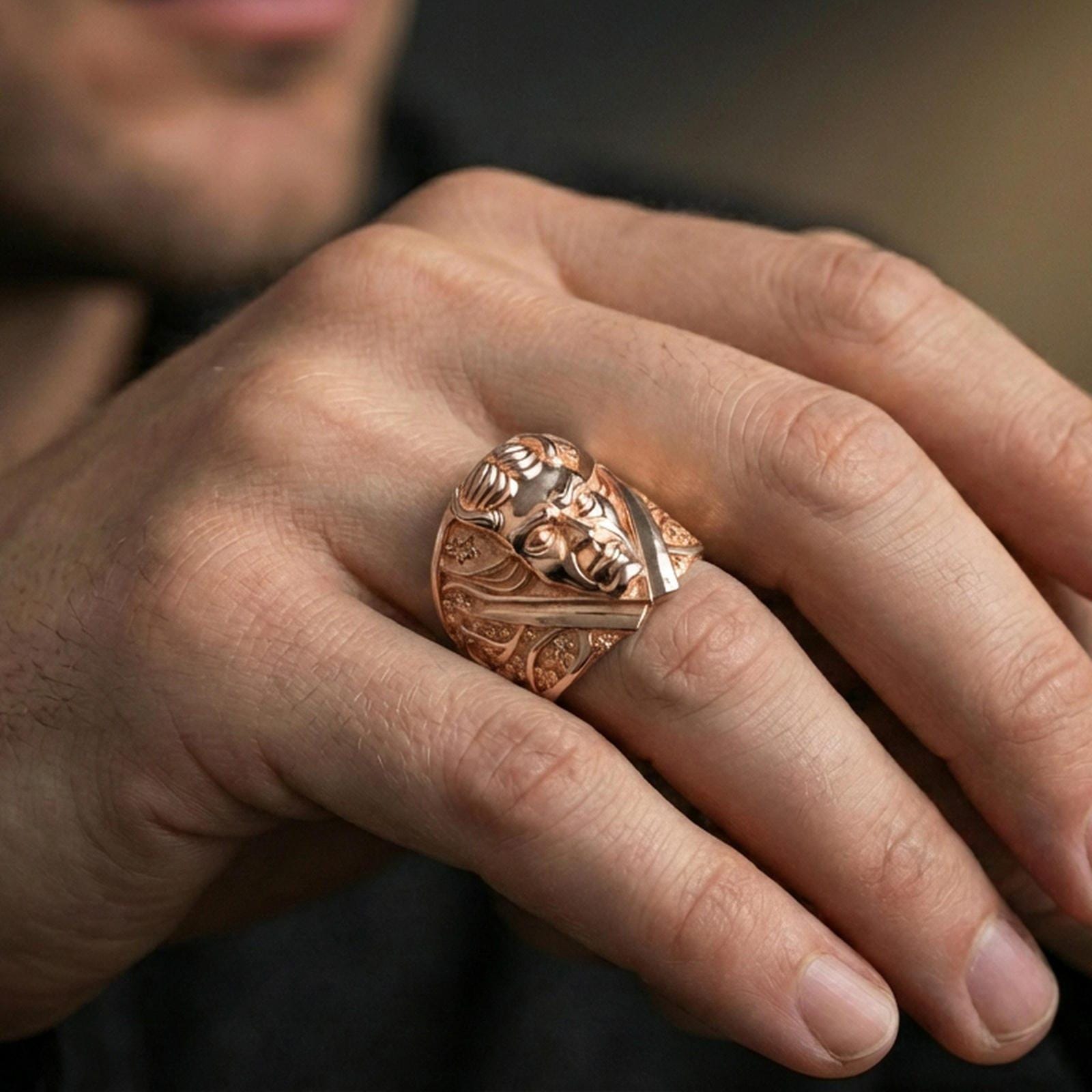 Rose gold plated demon face ring on a finger, lifestyle photo showing the high-relief sculpting and decorative engraved panels