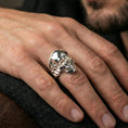 Load image into Gallery viewer, Polished silver skull ring on the finger, wearable photo emphasizing the sculpted teeth and clean gothic silhouette
