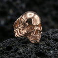 Load image into Gallery viewer, Gold plated skull ring with minimalist smooth head finish and high-relief jawline carving, product-only macro image on black volcanic rock
