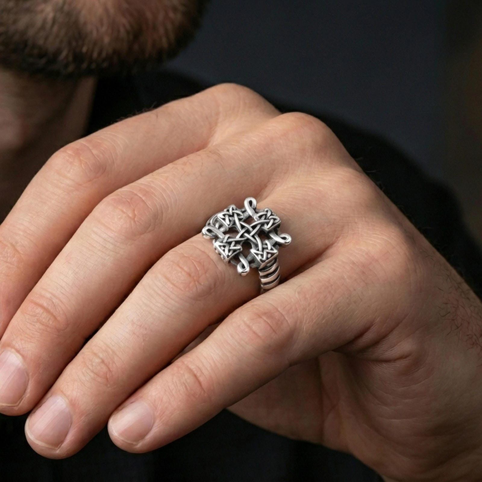 Polished silver Celtic knot cross ring on the finger, wearable photo emphasizing the crisp interwoven braid pattern and smooth finish