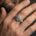 Load image into Gallery viewer, Polished silver Celtic windflower ring on the finger, wearable photo highlighting the crisp floral swirl center and interlace details

