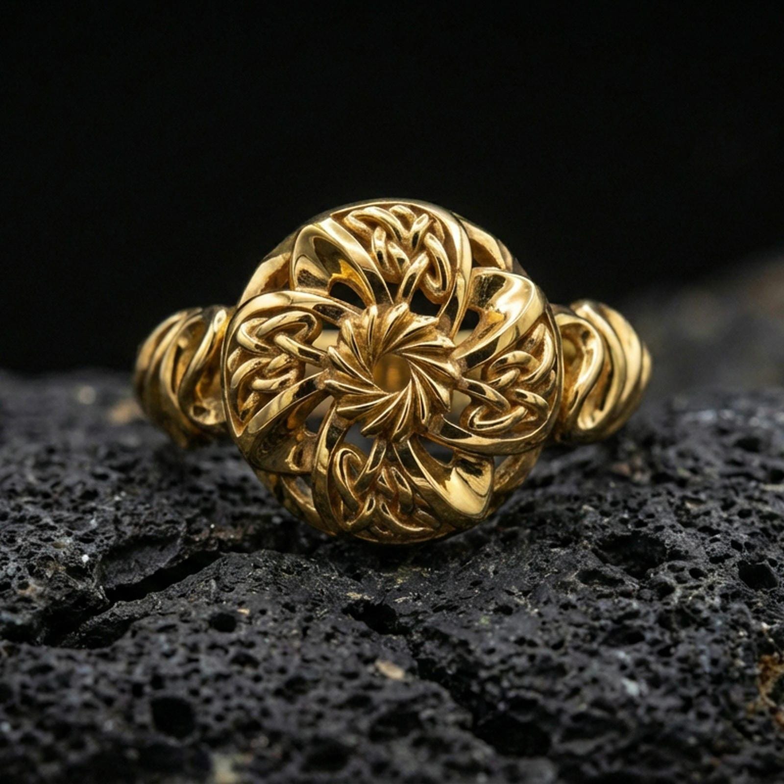Gold plated Celtic windflower ring with intricate openwork flower design and braided Celtic accents, product-only macro image on black volcanic rock