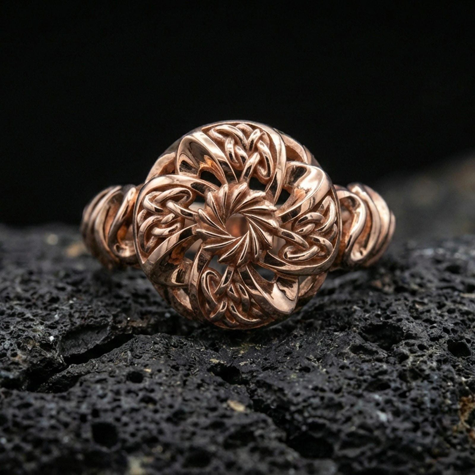 Rose gold plated Celtic windflower ring with floral rosette centerpiece and interwoven knot petals, close-up product shot on volcanic rock