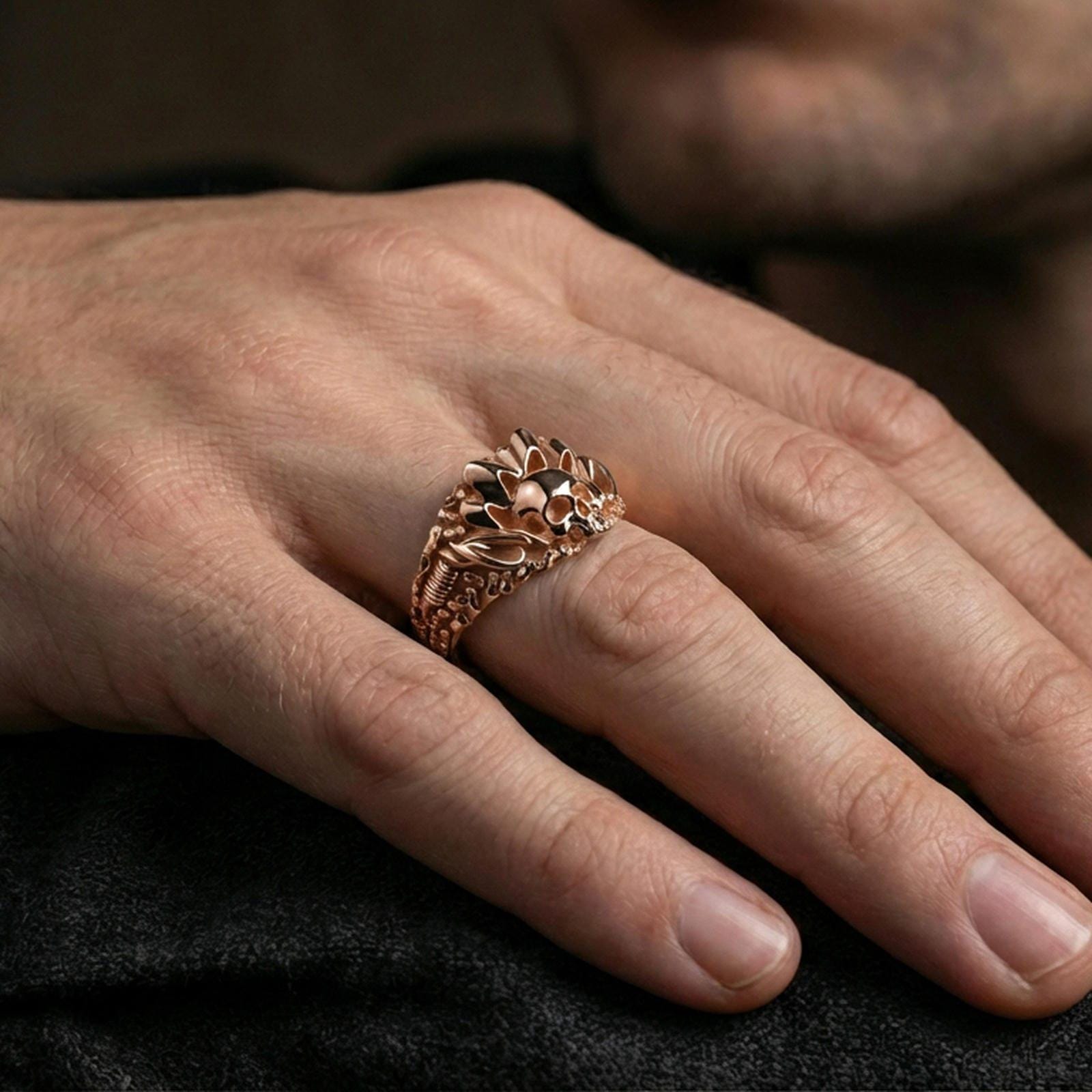 Rose gold plated skull ring on the finger, lifestyle shot showcasing the spiked crown design and chain-patterned sides