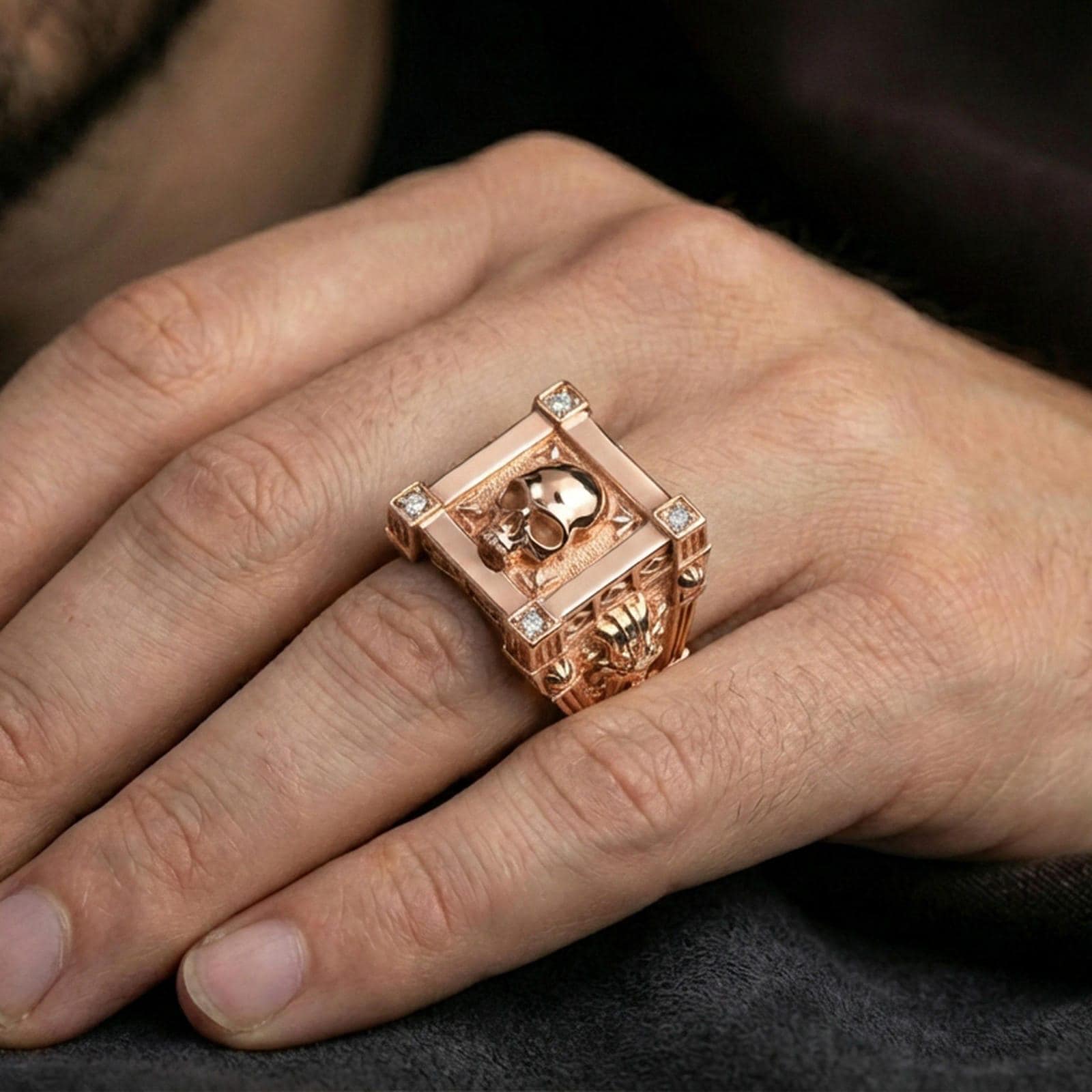 Rose gold plated framed skull ring on the finger, lifestyle shot emphasizing the corner-set lab diamond accents and bold skull motif