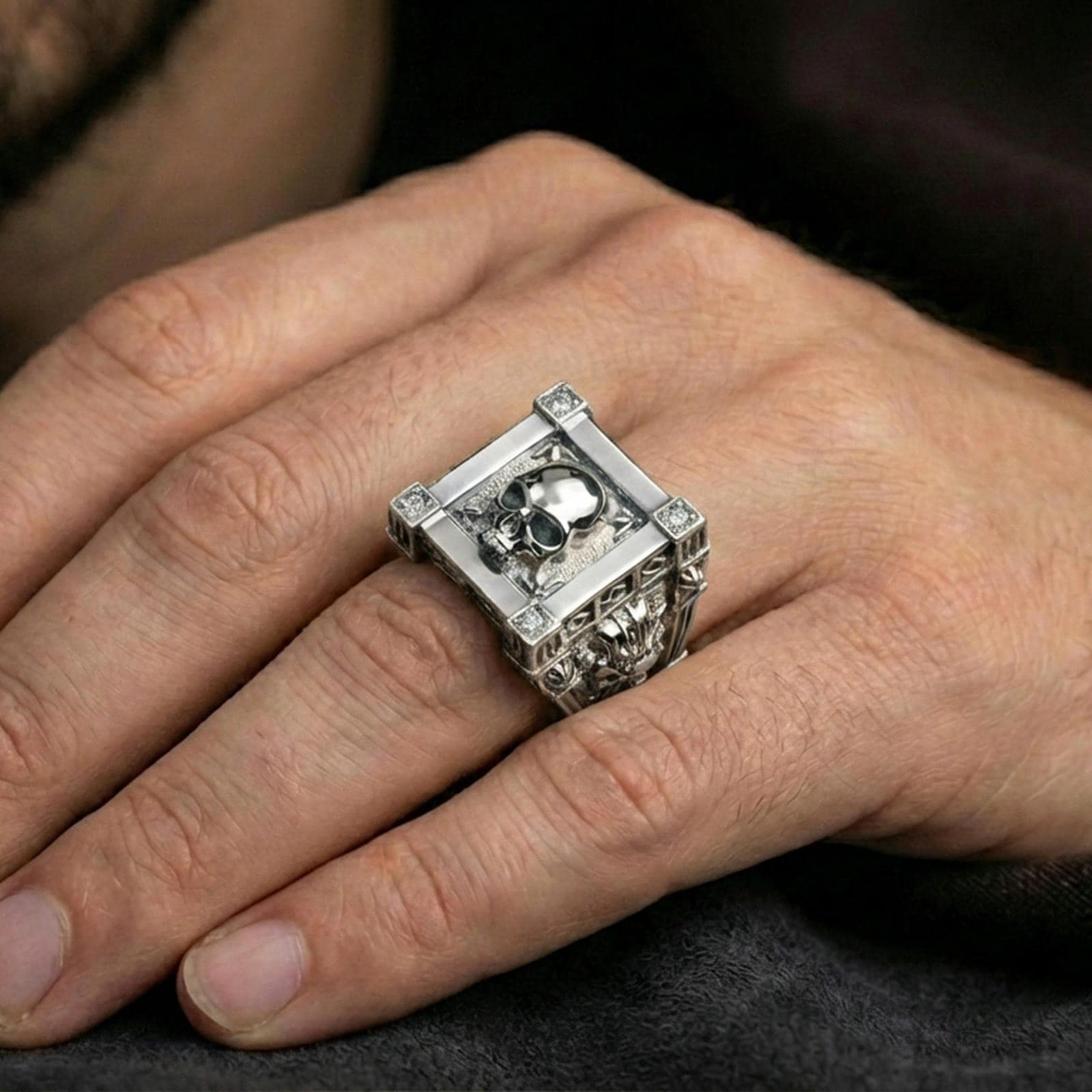 Polished silver skull ring on the finger with square frame design and lab diamond details, wearable close-up photo