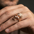 Load image into Gallery viewer, Rose gold plated tree bark skull ring worn on a finger, lifestyle shot focusing on carved woodgrain texture and skull detail
