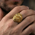 Load image into Gallery viewer, Gold plated smoke skull ring worn on a finger, close-up lifestyle image emphasizing the flowing curls and bold skull design
