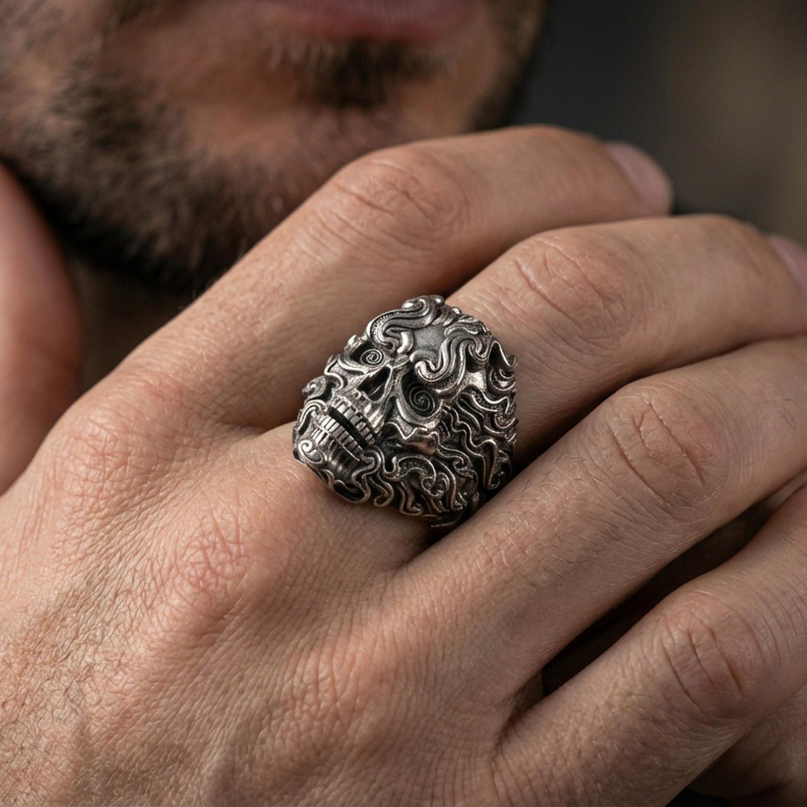 Oxidized smoke skull ring worn on a finger, lifestyle close-up highlighting swirling scrollwork and gothic statement look