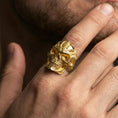 Load image into Gallery viewer, Gold plated futuristic skull ring worn on a finger, lifestyle close-up emphasizing the engraved biomechanical details
