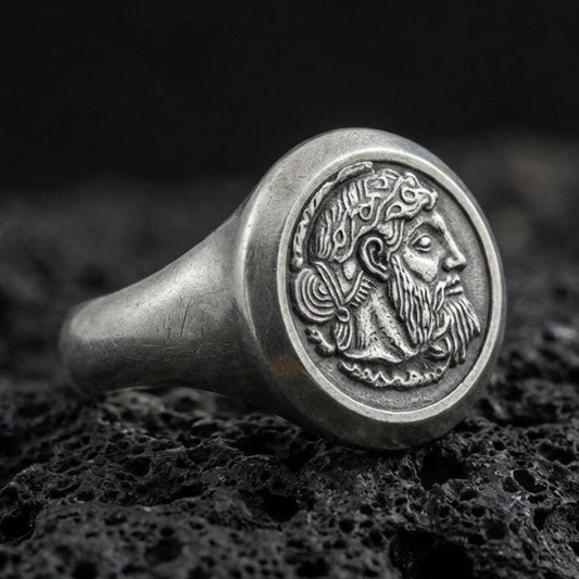 Oxidized sterling silver ancient coin signet ring with bearded ruler portrait relief, macro photo on black volcanic rock