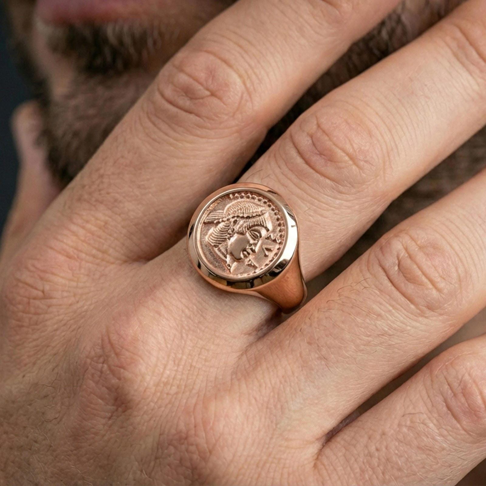 Rose gold plated Greek coin ring on the finger, close-up lifestyle image showing the antique coin portrait and smooth band