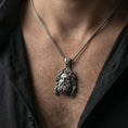 Load image into Gallery viewer, Oxidized deity head pendant necklace worn on neck, masculine lifestyle framing, braided chain and pendant centered
