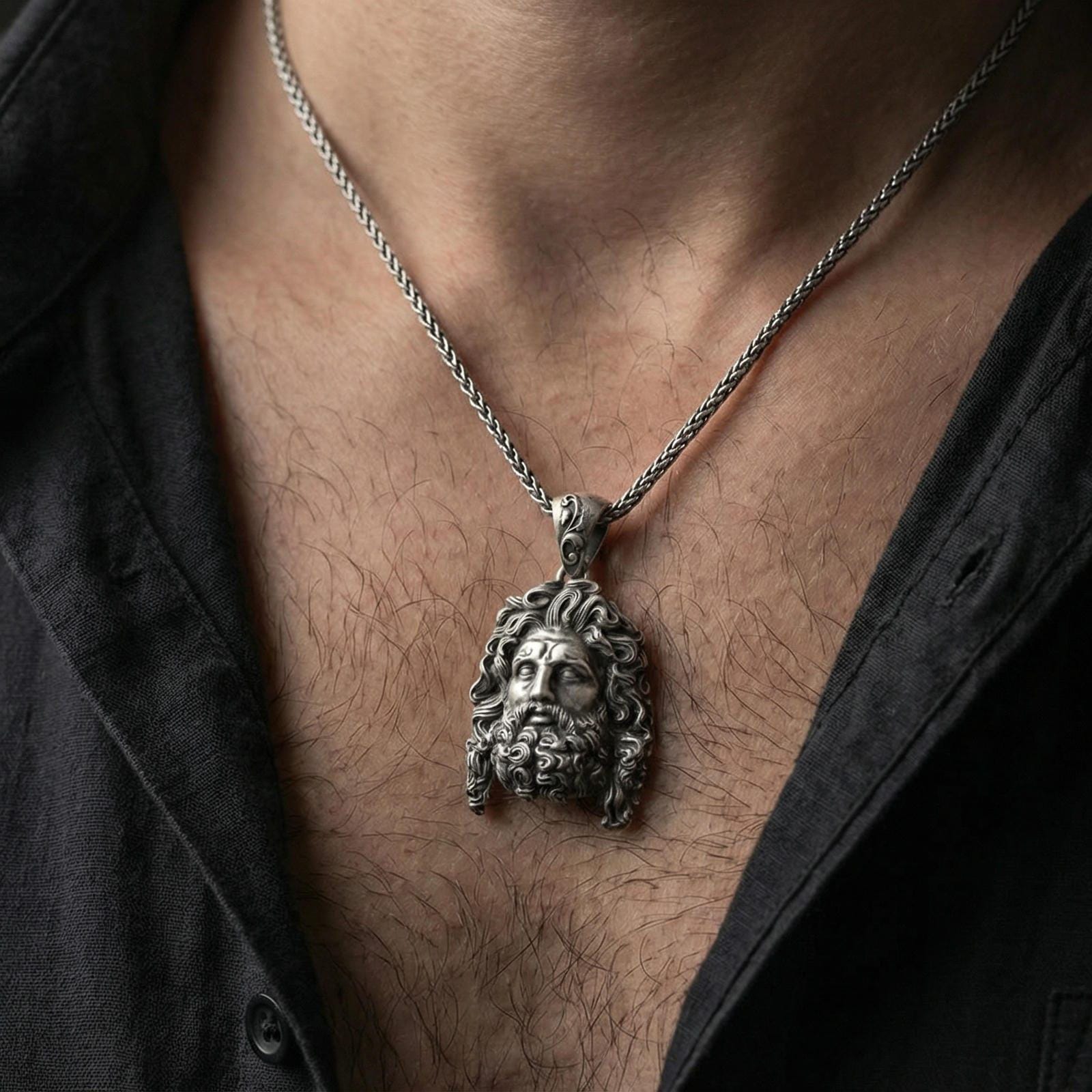 Oxidized deity head pendant necklace worn on neck, masculine lifestyle framing, braided chain and pendant centered