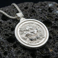 Load image into Gallery viewer, Polished silver guardian lion medallion necklace on volcanic rock, crisp relief detail and smooth bezel frame, close-up
