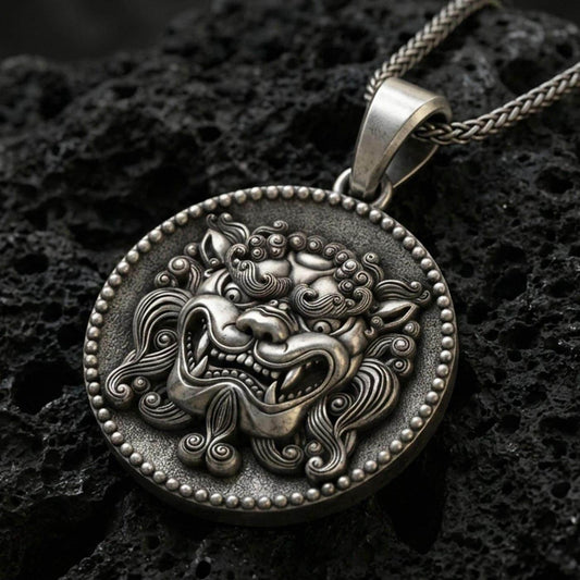 Oxidized sterling silver guardian lion medallion pendant on volcanic rock, beaded rim and bold relief detail, macro shot