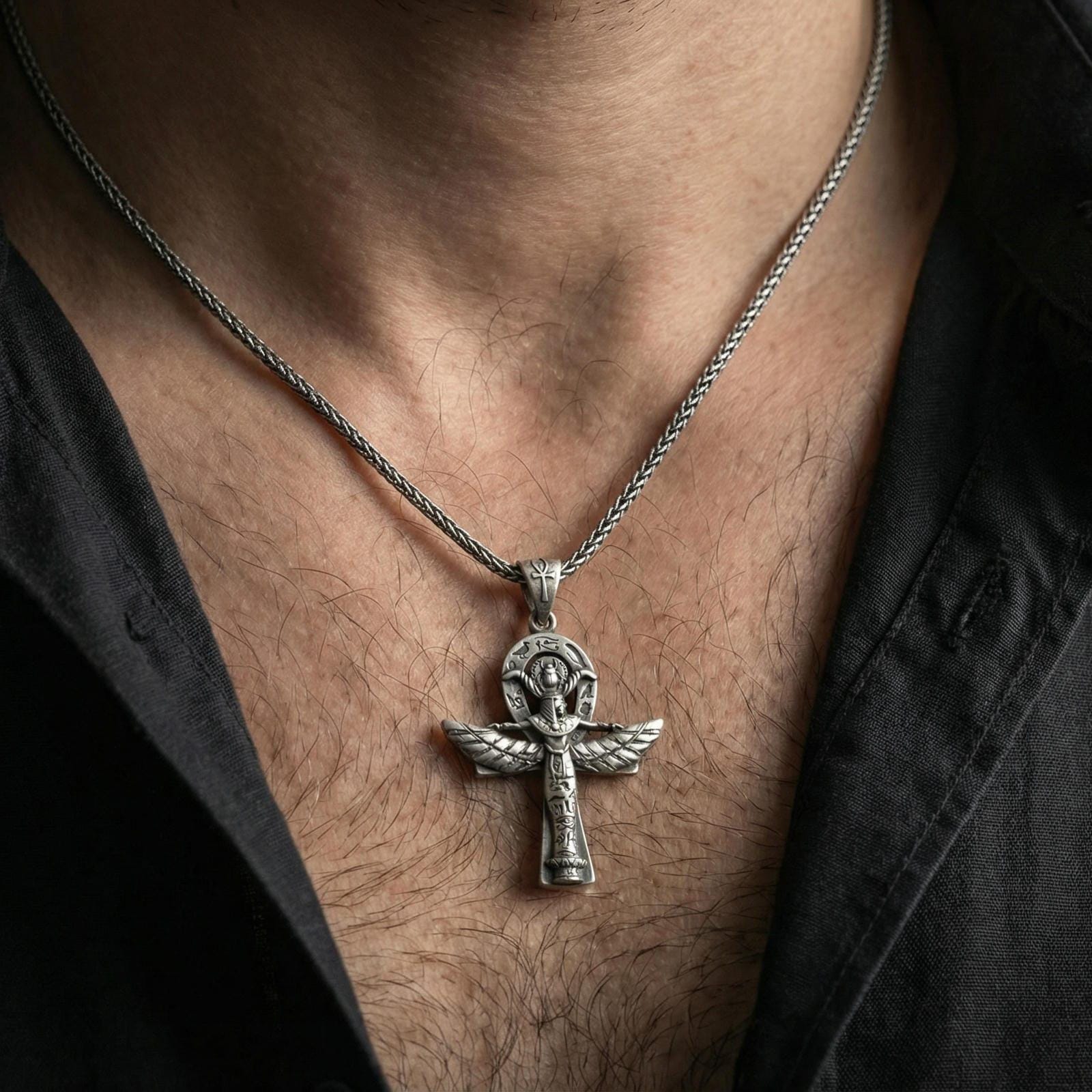 Oxidized Egyptian winged ankh cross necklace worn on neck, lifestyle close-up, pendant centered with braided chain