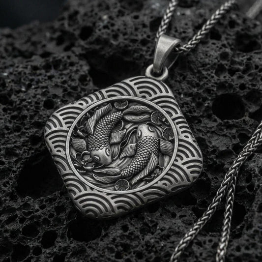 Oxidized sterling silver koi fish pendant on volcanic rock, twin koi relief in framed medallion, macro studio shot