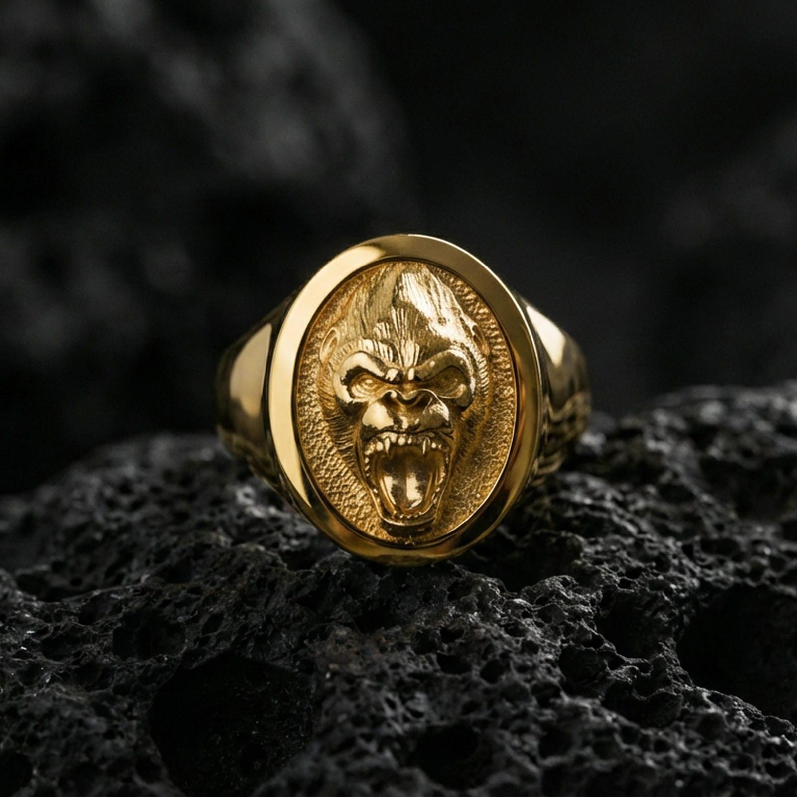 Gold plated gorilla head signet ring on volcanic rock, premium studio scene, fierce animal motif with bold relief detail