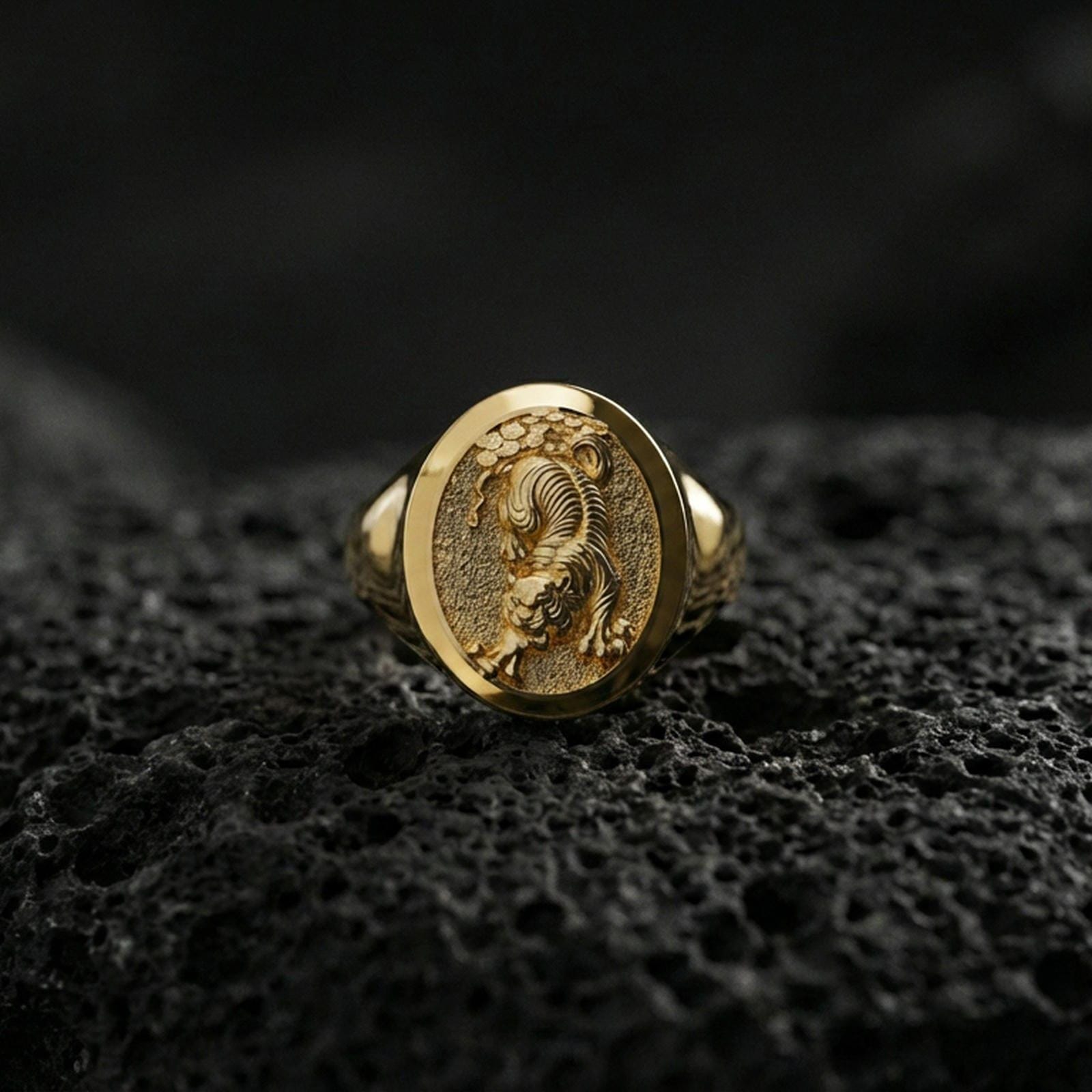 Gold plated Asian tiger signet ring on volcanic rock, premium studio scene, powerful predator motif with sharp relief detail