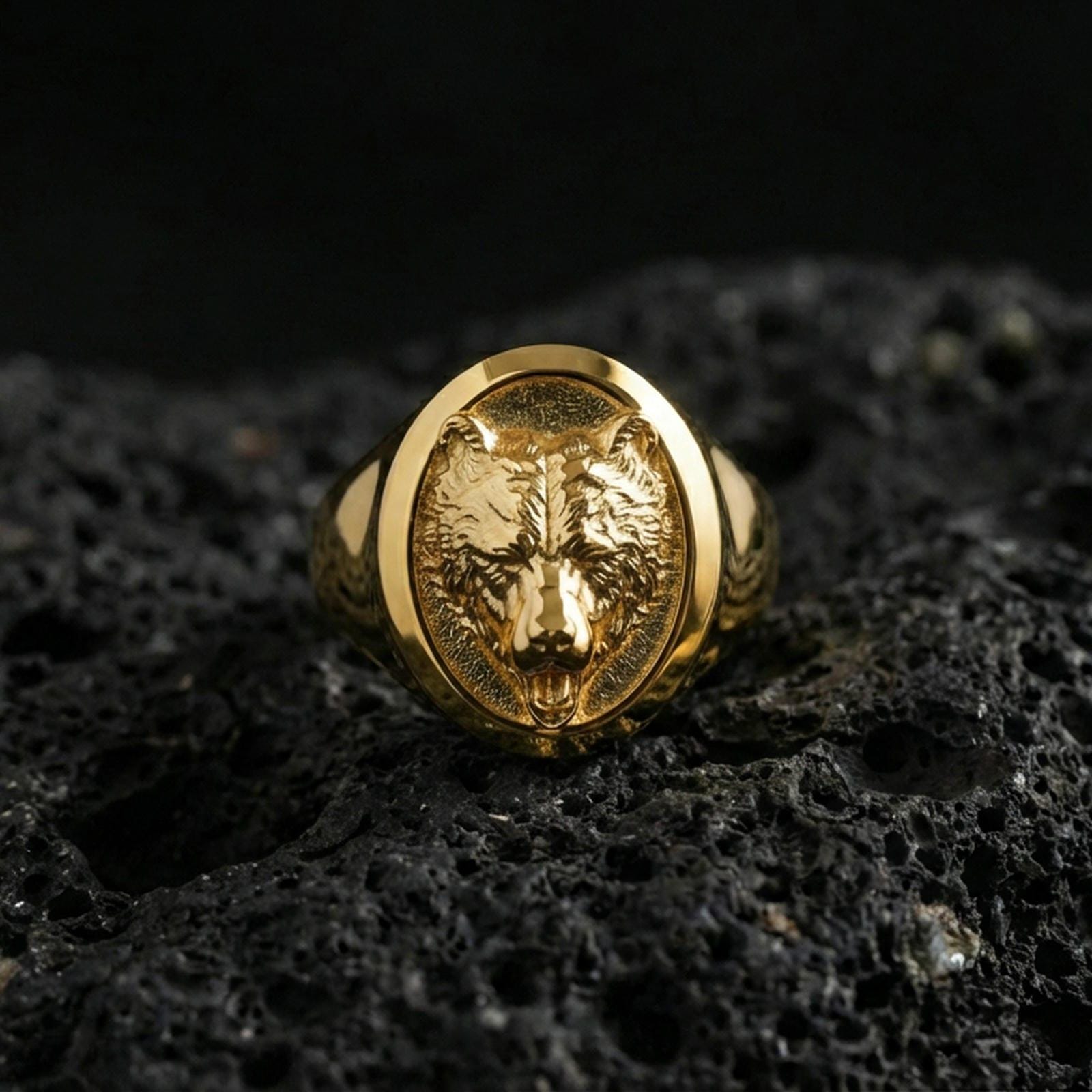 Gold plated bear head signet ring on volcanic rock, premium studio scene, strong animal totem motif with bold relief detail