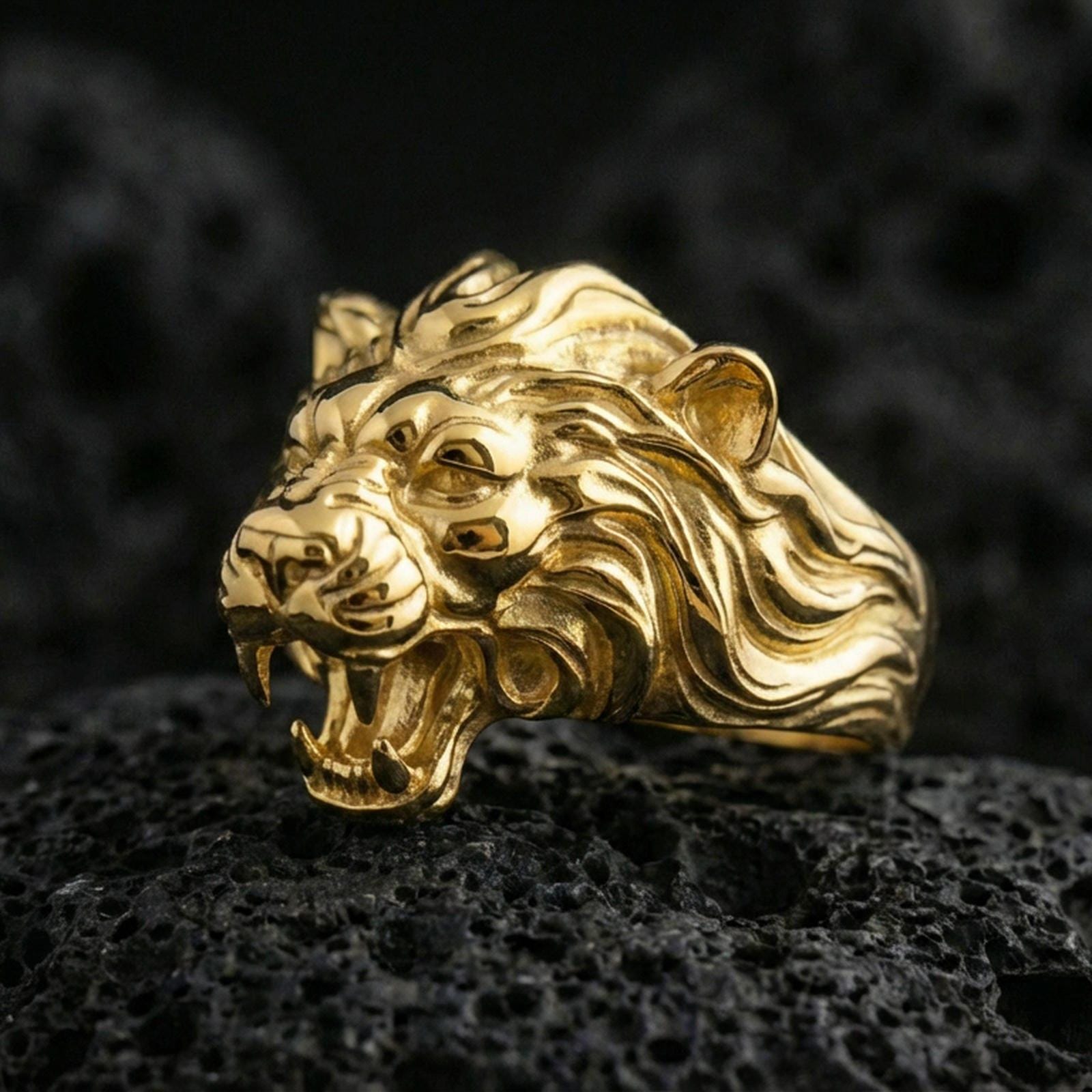 Gold plated angry lion king ring on volcanic rock, premium studio lighting, bold roaring lion head with deep sculpted texture