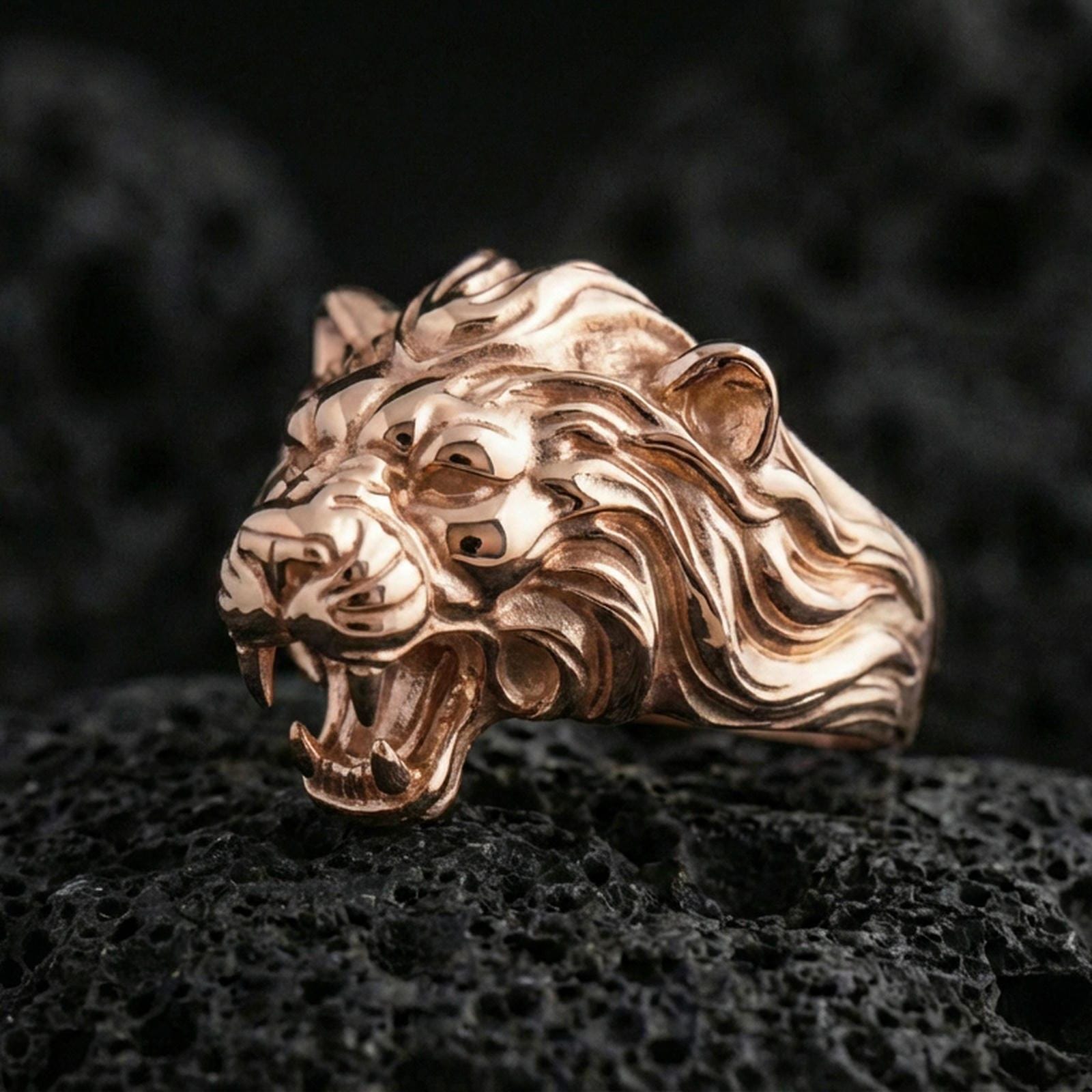 Rose gold plated angry lion king ring on volcanic rock, dramatic mane carving and open-jaw lion detail, luxury product close-up