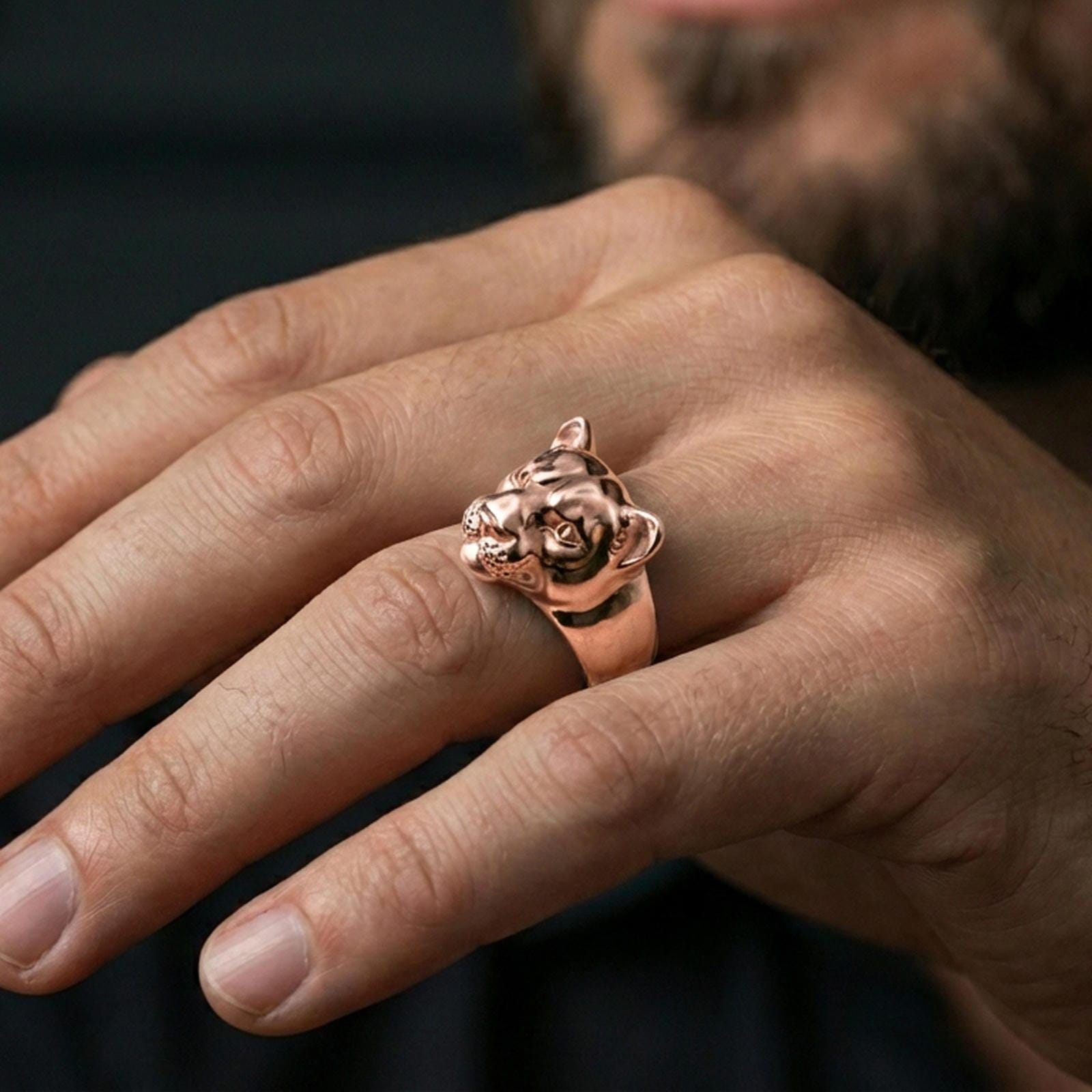 Rose gold plated puma head ring worn on finger, lifestyle wear photo, elegant feline statement ring highlighting eye detail