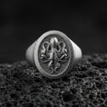 Load image into Gallery viewer, Oxidized sterling silver octopus signet ring on volcanic rock, raised octopus emblem on round face with textured background, macro product photo
