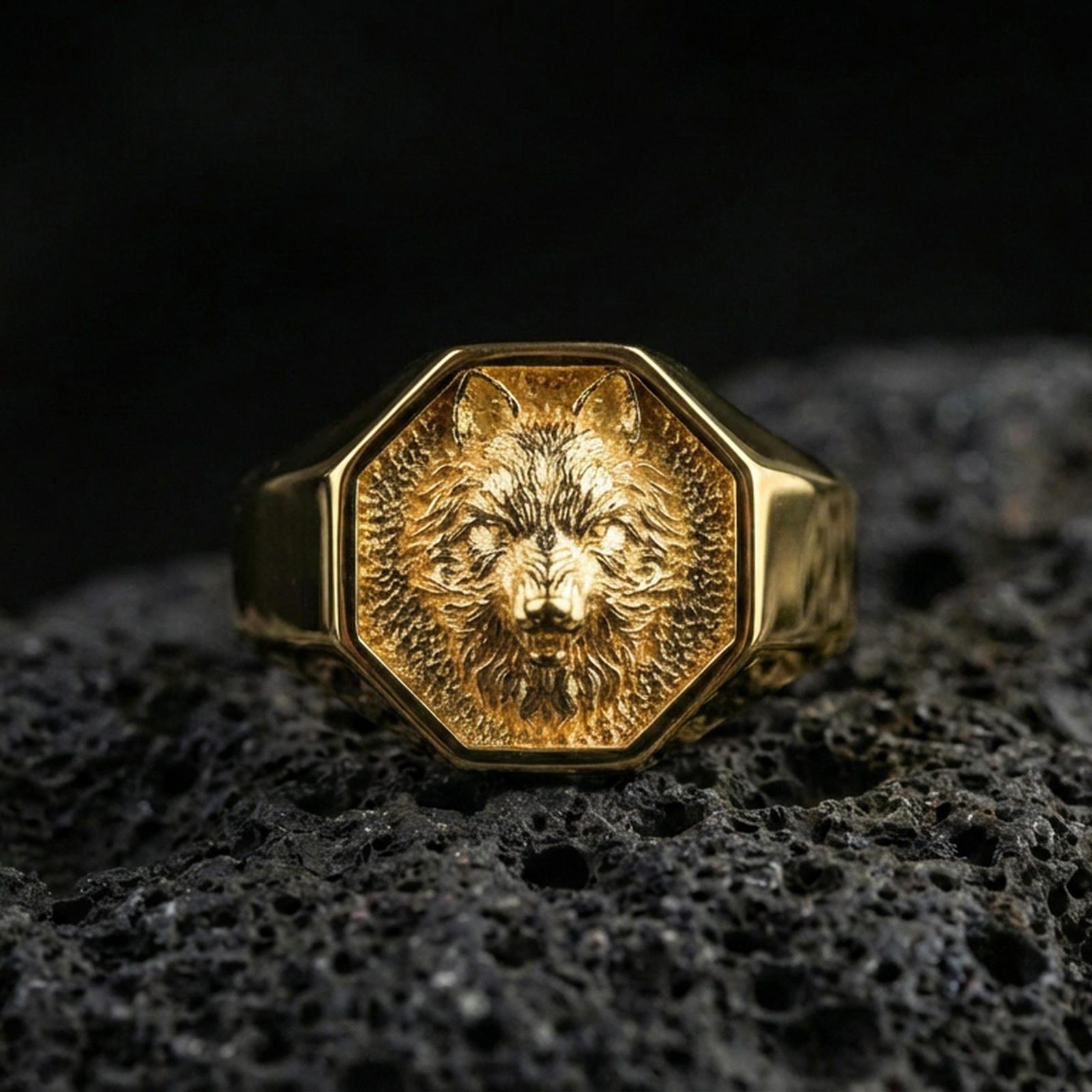 Gold plated wolf signet ring on volcanic rock, octagonal wolf crest ring with high-relief fur texture and recessed dark field, premium studio lighting