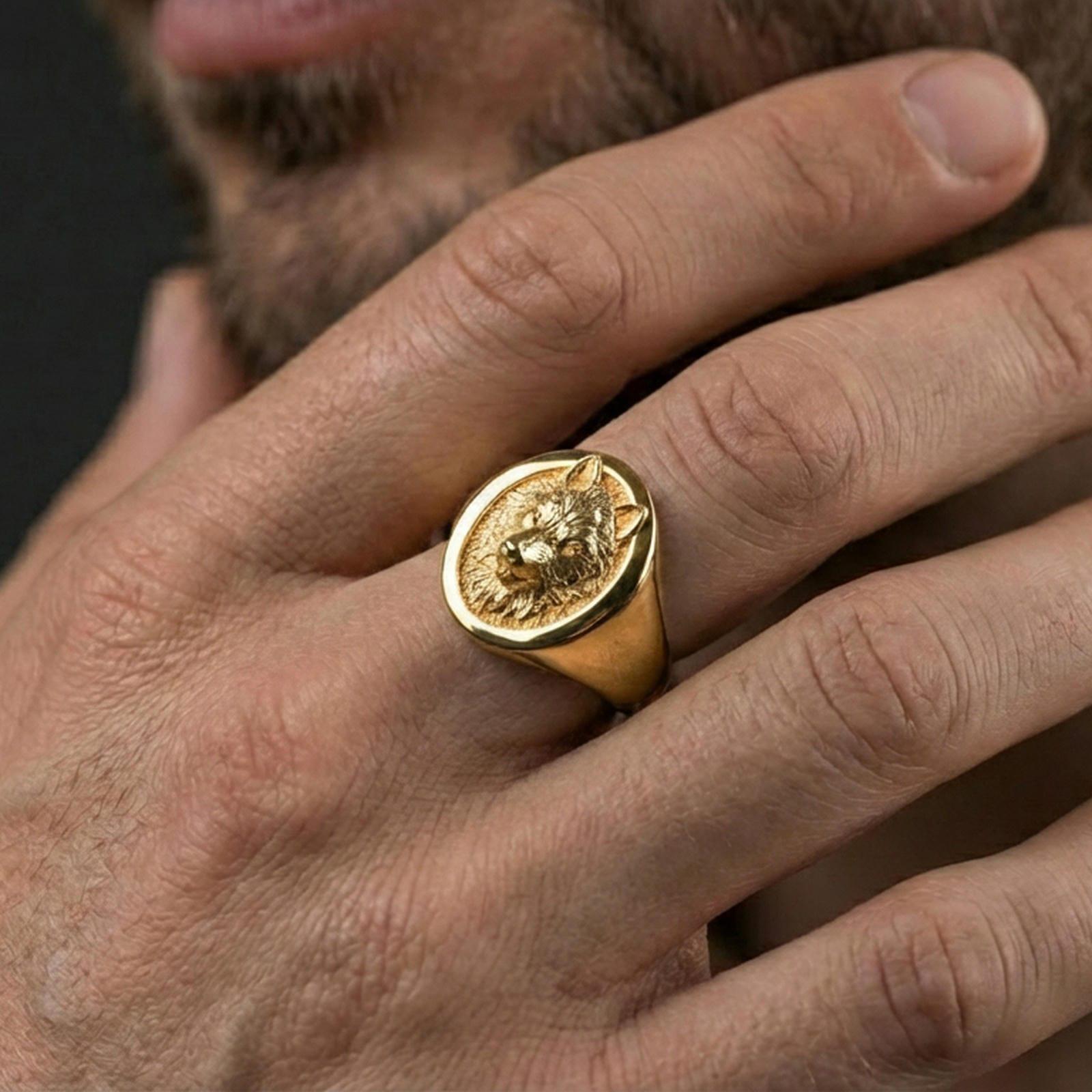 Gold plated oval wolf signet ring worn on finger, premium lifestyle wear photo with bold wolf totem face and sculpted fur details