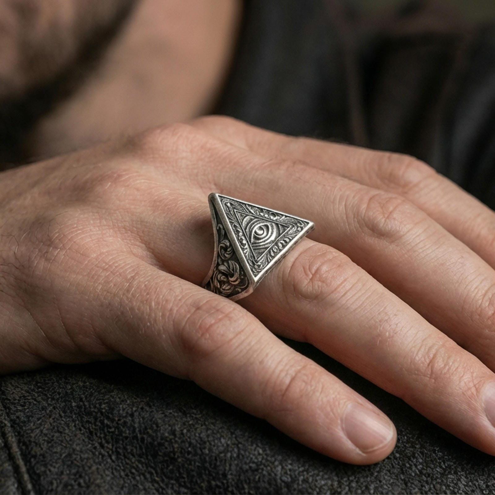 Oxidized triangle signet ring worn on a finger, close-up lifestyle photo highlighting the all-seeing eye and engraved shoulders