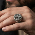 Load image into Gallery viewer, Oxidized owl skull signet ring worn on a finger, close-up lifestyle photo showing the engraved “THE WISE ARE SILENT” text
