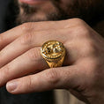 Load image into Gallery viewer, Gold plated owl and skull ring worn on a finger, close-up lifestyle image focusing on the circular quote engraving
