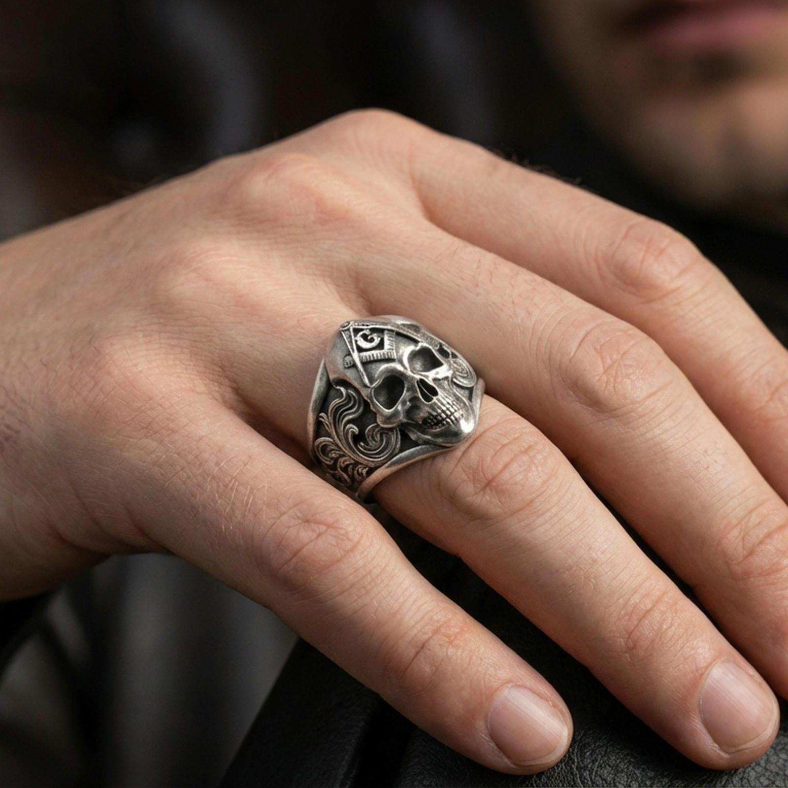 Oxidized Masonic skull ring worn on a finger, close-up lifestyle photo highlighting the compass-and-G emblem