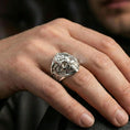 Load image into Gallery viewer, Polished silver Freemason skull ring on the finger, wearable macro showing the engraved scrollwork on the sides
